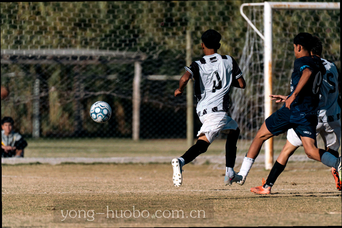 暗色房间内多块屏幕显示比分与数据条，屏幕光映在桌面，无人物正面特写